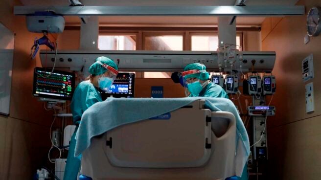 Dos profesionales sanitarios trabajan en la UCI del Hospital Vall d'Hebron de Barcelona. EFE/Alberto Estévez/Archivo