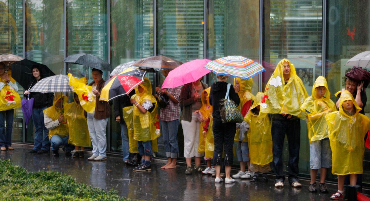 Πλήθος προσπαθεί να προστατευτεί από τη βροχή στο Βερολίνο - REUTERS/Pawel Kopczynski (GERMANY)