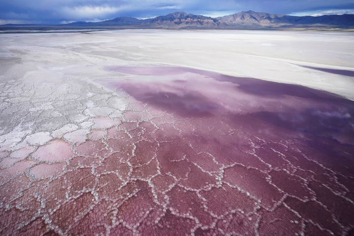 Pink water washes over a salt crust on May 4, 2021, along the receding edge of the Great Salt Lake. 