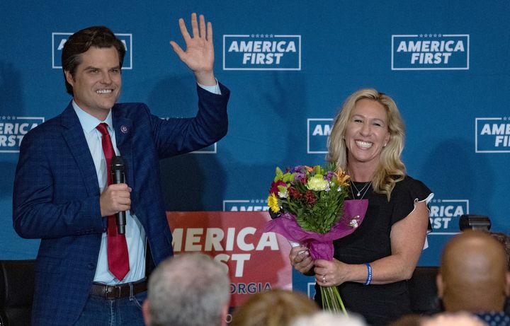 Rep. Matt Gaetz (R-Fla.) gives a bouquet to Rep. Marjorie Taylor Greene (R-Ga.) after they spoke at an "America First" rally in May in Dalton, Georgia.