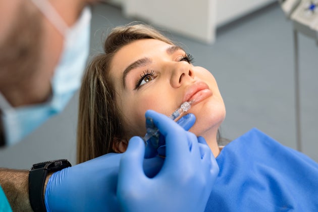 Attractive young woman is getting a rejuvenating facial injections at beauty clinic. The expert beautician...