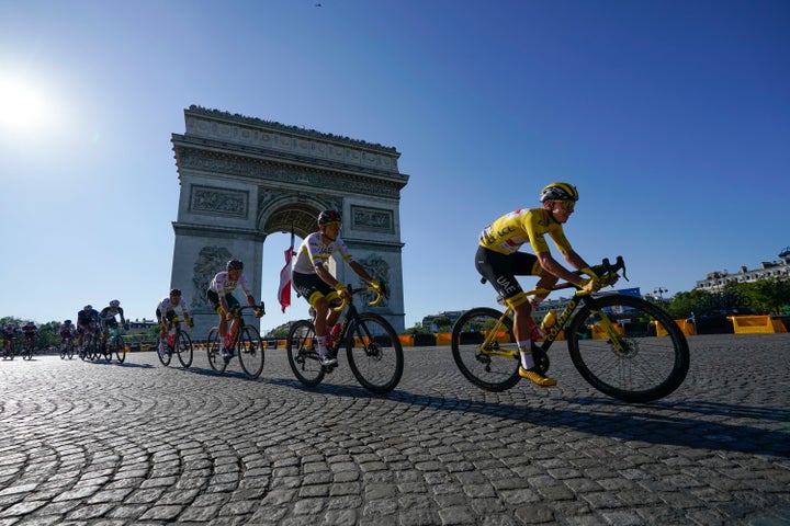 Cyclists pass the Arc de Triomphe during the twenty-first and last stage of the Tour de France cycling race in Paris, France,