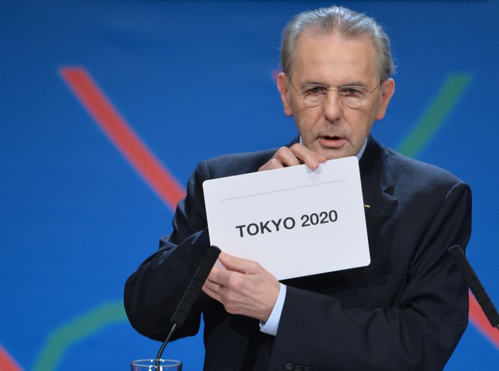 「TOKYO 2020」と書かれたカードを見せるロゲIOC会長（当時）