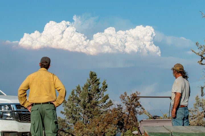 Fire Mitigation and Education Specialist Ryan Berlin (L) and home owner Bob Dillon watch the Bootleg Fire smoke cloud from Di