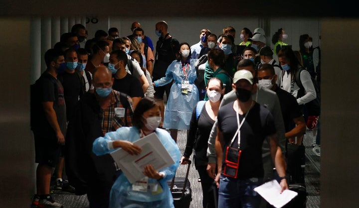 In this July 1, 2021, file photo, Olympic officials guide Ireland's athletes on their arrival at Narita international airport in Narita, east of Tokyo. 