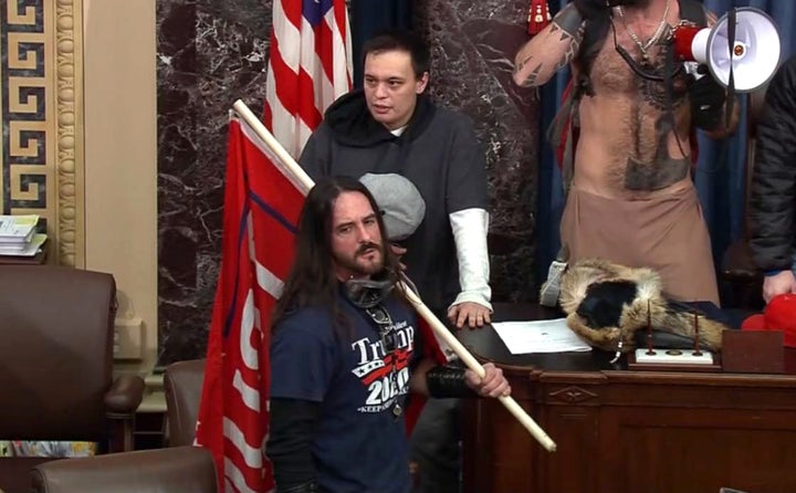 In this file image from U.S. Capitol Police video, Paul Allard Hodgkins, 38, of Tampa, Fla., front, stands in the well on the floor of the U.S. Senate on Jan. 6, 2021, at the Capitol in Washington.
