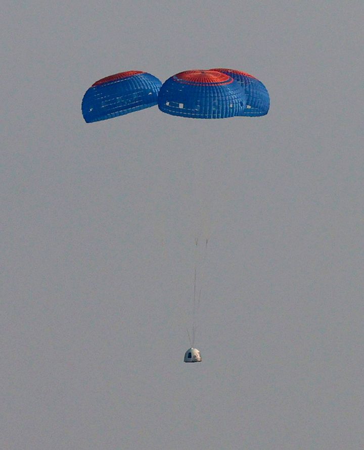  Blue Origin’s New Shepard crew capsule descends on the end of its parachute system carrying Jeff Bezos along with his brother Mark Bezos, 18-year-old Oliver Daemen, and 82-year-old Wally Funk on July 20, 2021 in Van Horn, Texas. Mr. Bezos and the crew are riding in the first human spaceflight for the company. (Photo by Joe Raedle/Getty Images)