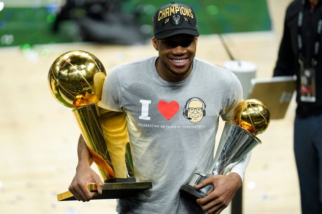 O Γιάννης Αντετοκούνμπο με τα τρόπαια του πρωταθλήματος και του MVP των τελικών του NBA ανά χείρας (AP Photo/Paul Sancya)