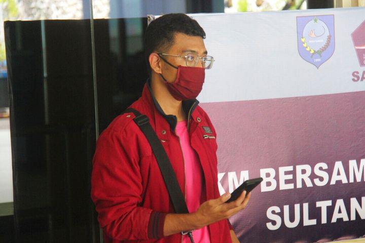 In this July 18, 2021, photo, a man who used a fake identity arrives at the Sultan Babullah airport in Ternate, Indonesia. The man with the coronavirus boarded a domestic flight disguised as his wife, wearing a niqab covering his face and carrying fake IDs and a negative PCR test result. He was arrested upon landing and tested positive for COVID-19. (AP Photo/Harmoko)