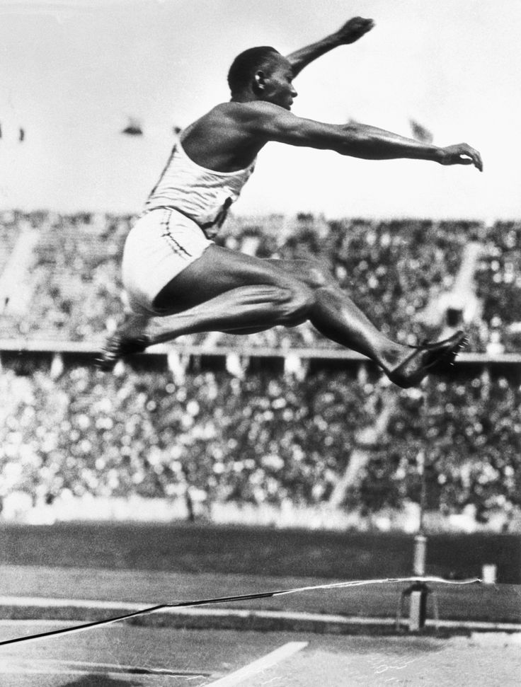 U.S. track star Jesse Owens makes the long jump that set an Olympic record in Berlin at the 1936 Olympic Games. His four gold medals exploded Adolf Hitler's German master race myth. 