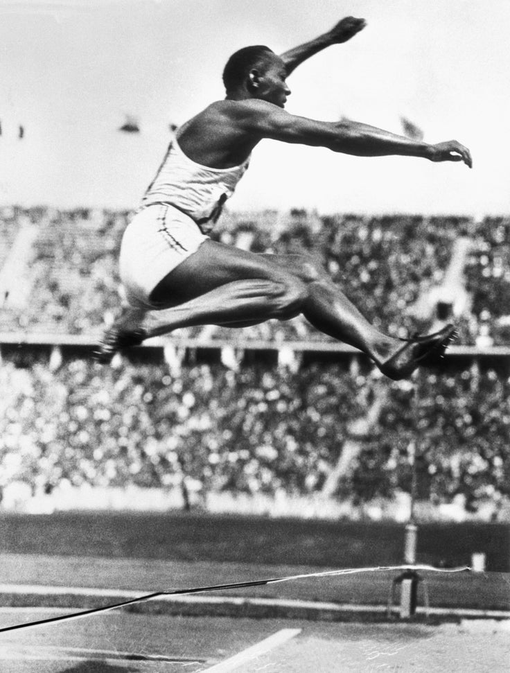 U.S. track star Jesse Owens makes the long jump that set an Olympic record in Berlin at the 1936 Olympic Games. His four gold medals exploded Adolf Hitler's German master race myth.