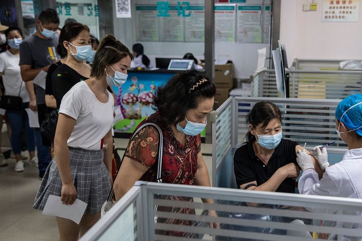 Personal sanitario chino vacunando a un grupo de personas en Wuhan