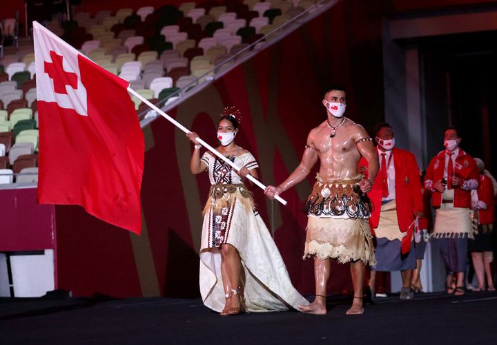 TOKYO, JAPAN - JULY 23: Flag bearers Malia Paseka and Pita Taufatofua of Team Tonga lead their team out during the Opening Ceremony of the Tokyo 2020 Olympic Games at Olympic Stadium on July 23, 2021 in Tokyo, Japan. (Photo by Hannah McKay - Pool/Getty Images)
