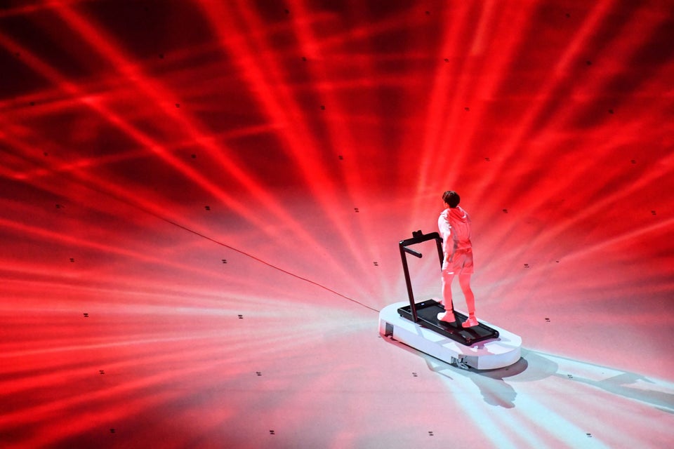 An overview shows a performer walking on a treadmill during the opening
