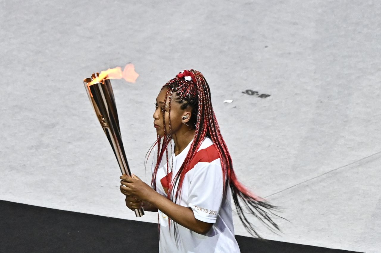 Team Japan's Naomi Osaka carries the Olympic torch. 