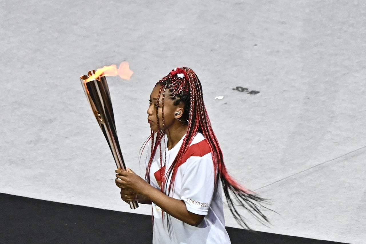 Team Japan's Naomi Osaka carries the Olympic torch.