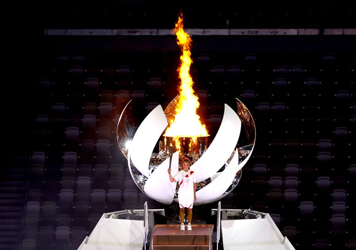 TOKYO, JAPAN - JULY 23: Naomi Osaka of Team Japan lights the Olympic cauldron with the Olympic torch during the Opening Ceremony of the Tokyo 2020 Olympic Games at Olympic Stadium on July 23, 2021 in Tokyo, Japan. (Photo by Laurence Griffiths/Getty Images)