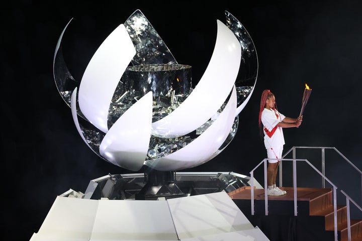 Tennis player Naomi Osaka lights the Olympic Cauldron atop a mini Mount Fuji at the opening ceremony of the Tokyo 2020 Summer