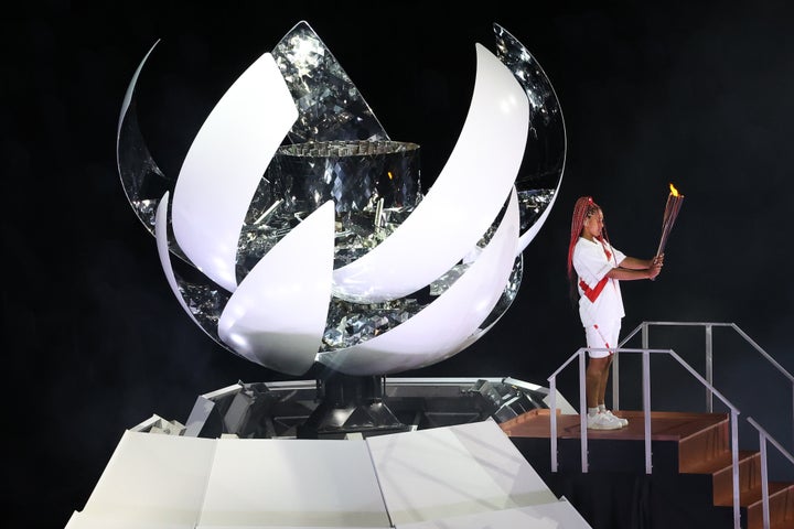 Tennis player Naomi Osaka lights the Olympic Cauldron atop a mini Mount Fuji at the opening ceremony of the Tokyo 2020 Summer Olympic Games.