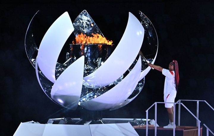 Japanese tennis player Naomi Osaka lights the flame of hope in the Olympic Cauldron during the opening ceremony of the Tokyo 2020 Olympic Games.