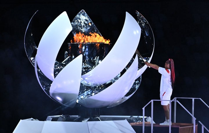 Japanese tennis player Naomi Osaka lights the flame of hope in the Olympic Cauldron during the opening ceremony of the Tokyo
