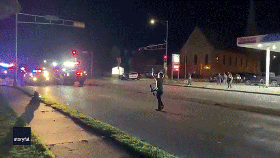 A squad of armored vehicles glides by Kyle Rittenhouse moments after he shot two people in Kenosha, Wisconsin, on Aug. 25, 2020.