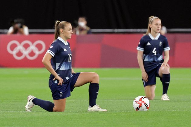 7月21日のサッカー女子予選リーグで、片膝をつくイギリス代表チーム。対戦するチリ代表チームも片膝をつき、連帯を示した。