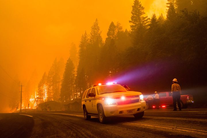 A firefighter vehicle turns around as active flames reach highway 70 in northern California.