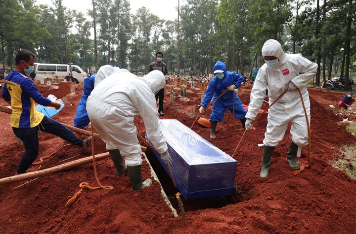 Eθελοντές θάβουν πτώμα νεκρού από κορονοϊό στη Δυτική Τζάβα της Ινδονησίας. (AP Photo/Achmad Ibrahim)