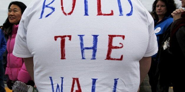 A man wears a hand-lettered "Build the Wall" t-shirt while waiting in line for a campaign rally with U.S. Republican presidential candidate Donald Trump in Portsmouth, New Hampshire February 4, 2016. REUTERS/Brian Snyder