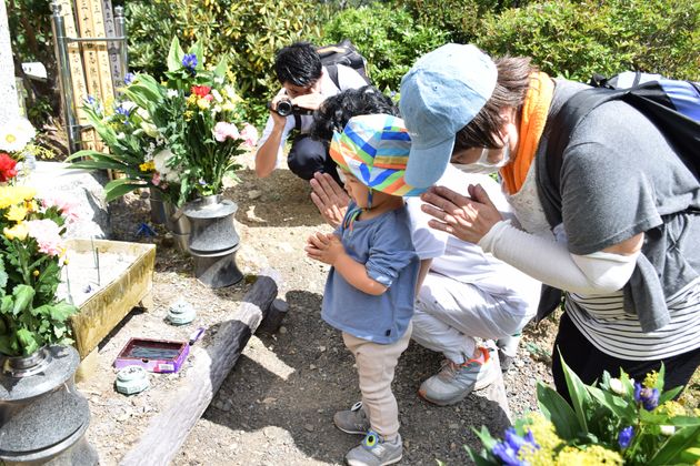 日航機墜落事故の現場に建つ「昇魂之碑」の前で手を合わせる遺族ら＝2020年8月12日撮影