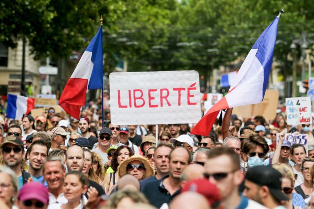 MARSEILLE, FRANCE - 2021/07/24 : Un activiste tient une pancarte pendant la manifestation contre le pass santé à Marseille. Des milliers de personnes manifestent contre un projet de loi qui doit être voté pour étendre le pass santé aux restaurants, aux centres commerciaux et au personnel hospitalier afin d'endiguer la propagation du virus covid-19, selon le gouvernement. (Photo de Denis Thaust/SOPA Images/LightRocket via Getty Images)