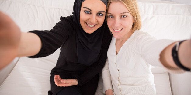 Smiling female friends taking photo of themselves