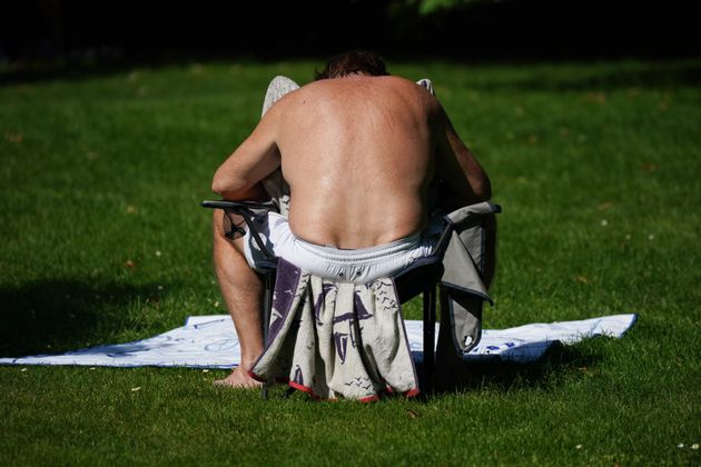 A man sunbathing in St James's Park, London on the hottest day of the year so far.