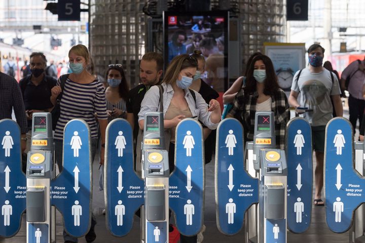 Commuters, most of them continuing to wear face masks, at Waterloo station