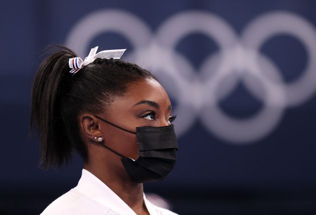 La gymnaste Simone Biles, de l'équipe des États-Unis, regarde son équipe aux barres asymétriques à la suite de son retrait de la compétition après n'avoir concouru qu'au saut, lors de la finale féminine par équipe des JO de Tokyo au centre de gymnastique Ariake, le 27 juillet 2021 à Tokyo, au Japon. (Photo by Laurence Griffiths/Getty Images)