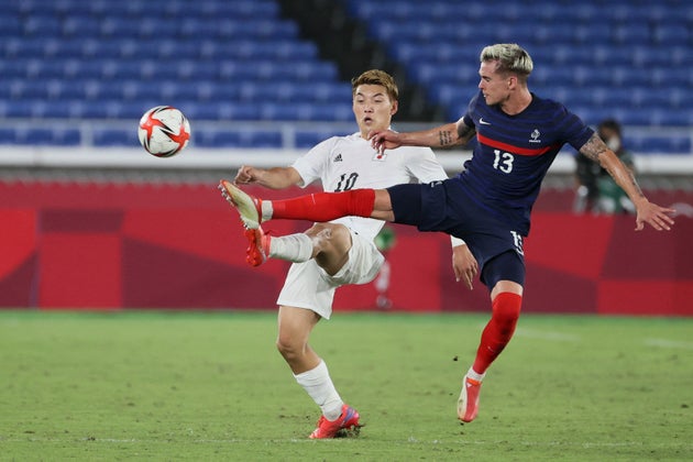 Le Japonais Ritsu Doan face au défenseur français Clement Michelin lors du match Japon-France des JO de Tokyo, le 28 juillet 2021 à Yokohama International Stadium de Yokohama
