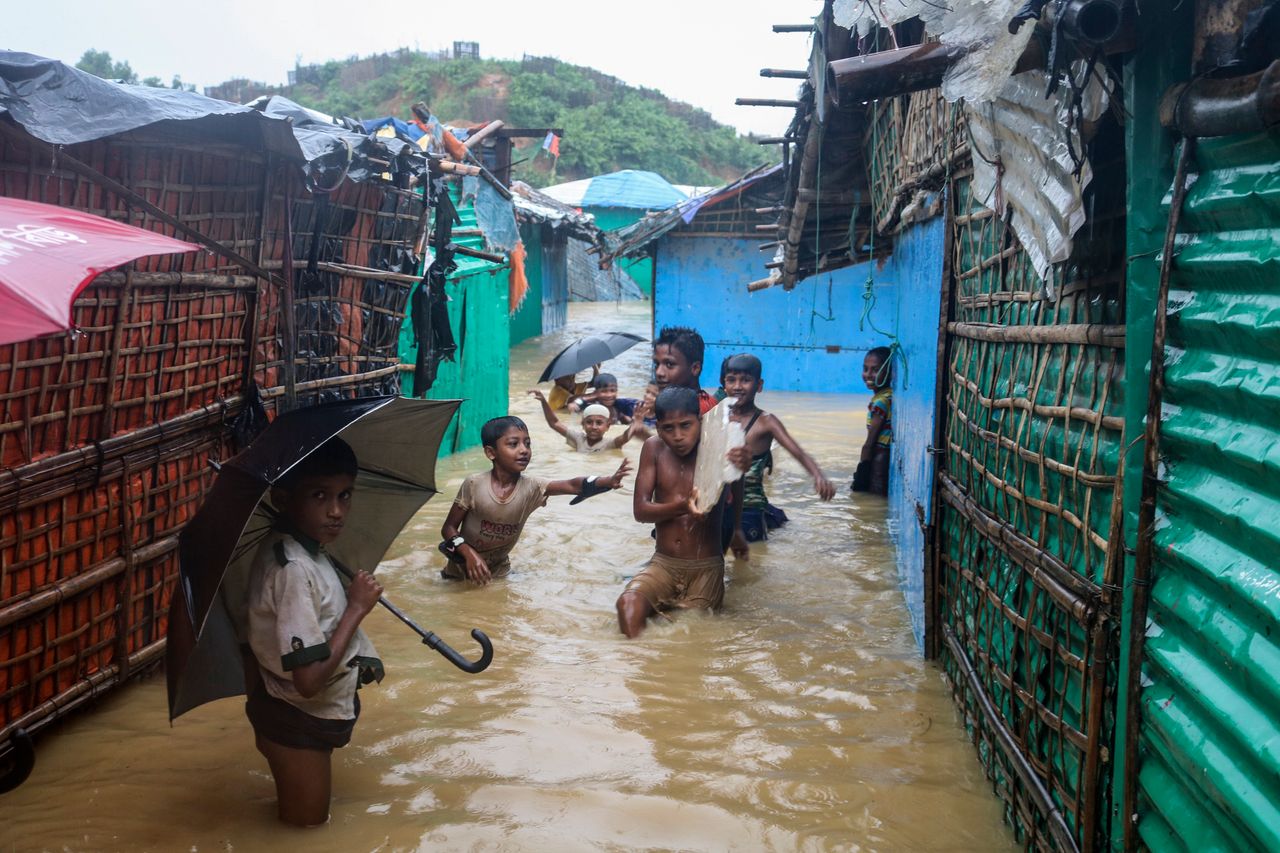 Rohingya refugee children play in floodwaters at the Rohingya refugee camp in Kutupalong, Bangladesh on Wednesday.