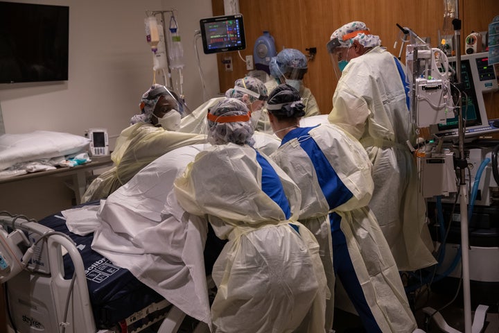 A "prone team," wearing personal protective equipment (PPE), turns a COVID-19 patient onto his stomach in a Stamford Hospital intensive care unit (ICU) in Stamford, Connecticut. 