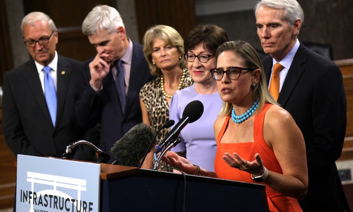 Sen. Kyrsten Sinema (D-Ariz.) speaks as (from left) Sens. Kevin Cramer (R-N.D.), Bill Cassidy (R-La.), Lisa Murkowski (R-Alaska), Susan Collins (R-Maine) and Rob Portman (R-Ohio) listen during a news conference after a procedural vote for the bipartisan infrastructure framework.