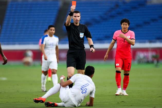 With zero fan pressure, referee Kabakov Georgi gives a red card to Carlos Melendez of Honduras during the men's Group B match at the Tokyo Games.