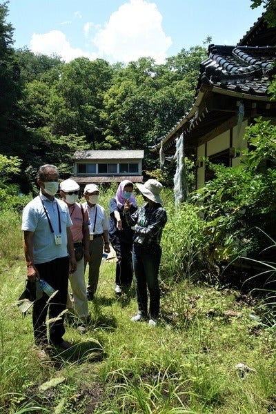 三瓶さんの自宅前で語り合う原告団の住民ら＝2021年7月19日、福島県浪江町津島