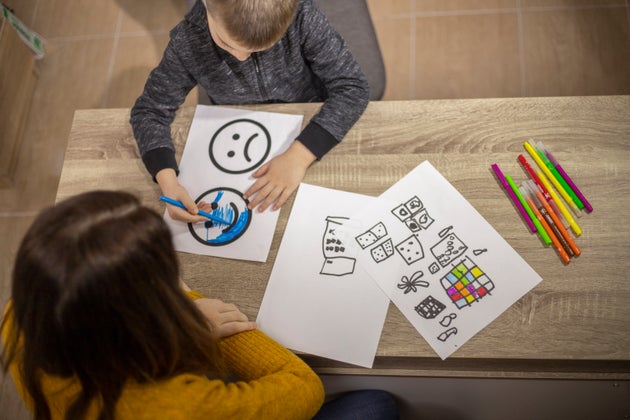 Five years old boy drawing at his educator's office.