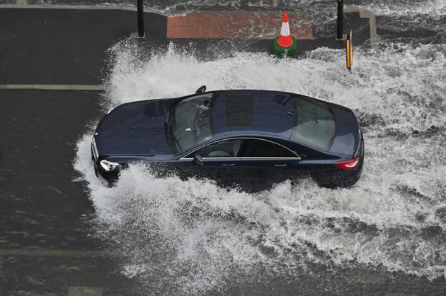 A car drives through deep water on a flooded road in Nine Elms, London on July 25 during heavy rain