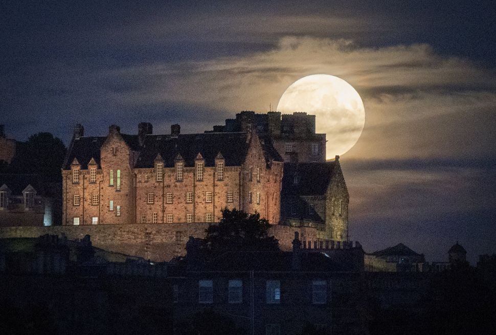 The full moon rises behind Edinburgh Castle. Otherwise known as Thunder Moon, the July full moon is synonymous with summer storms