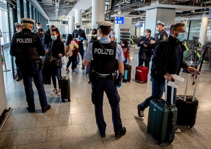 Γερμανοί αστυνομικοί ελέγχουν για αρνητικά τεστ κορονοϊού επιβάτες που φτάνουν στο αεροδρόμιο της Φρανκφούρτης από τη Μαγιόρκα (AP Photo/Michael Probst, File)