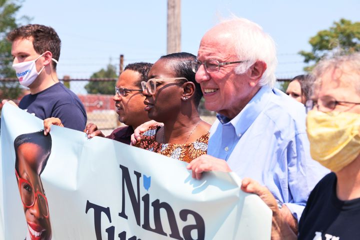 Minnesota Attorney General Keith Ellison (center left) and Sen. Bernie Sanders (center right) march to the polls with congressional candidate Nina Turner (center) on Saturday.