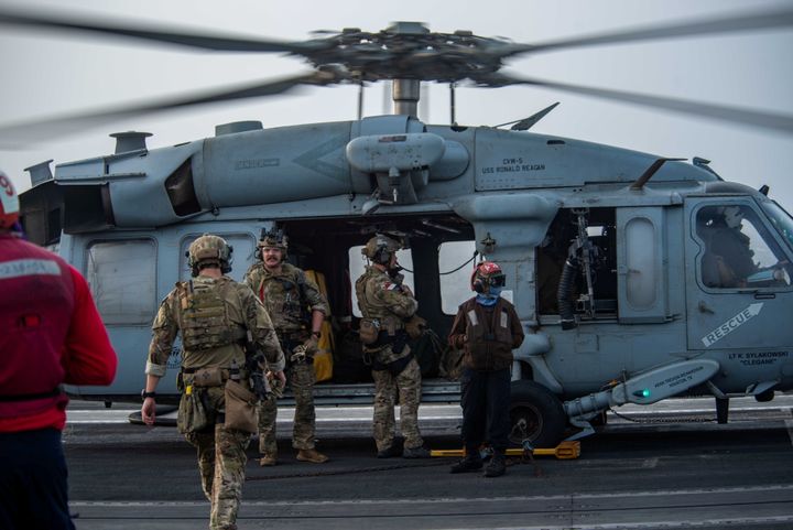 Nαύτες που έχουν ανατεθεί στην κινητή μονάδα διάθεσης εκρηκτικών όπλων (EODMU) 5 επιβιβάζονται σε ελικόπτερο MH-60S Sea Hawk, προσαρτημένο στo «Golden Falcons» της Helicopter Sea Combat Squadron (HSC) 12, στο κατάστρωμα πτήσης του αεροπλανοφόρου USS Ronald Reagan (CVN 76), το οποίο ανταποκρίνεται σε έκκληση για βοήθεια από το τάνκερ Mercer. ( 30 Ιουλίου 2021- U.S. Navy/Handout via REUTERS ATTENTION EDITORS. THIS IMAGE HAS BEEN SUPPLIED BY A THIRD PARTY.)