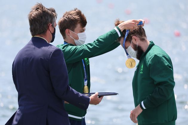 Ireland's Fintan McCarthy places a gold medal on teammate Paul O'Donovan at the medal ceremony for men's lightweight double sculls on July 28.