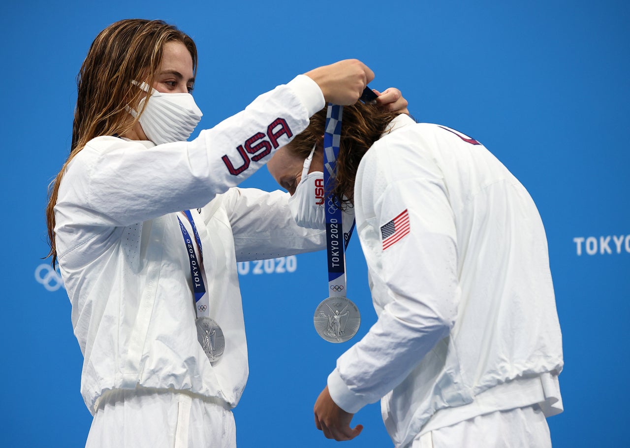 Katie McLaughlin of Team United States places a silver medal around the neck of her teammate Katie Ledecky during the ceremony for the women's 4 x 200-meter freestyle relay on July 29. McLaughlin and Ledecky earned silver alongside teammates Allison Schmitt and Paige Madden.